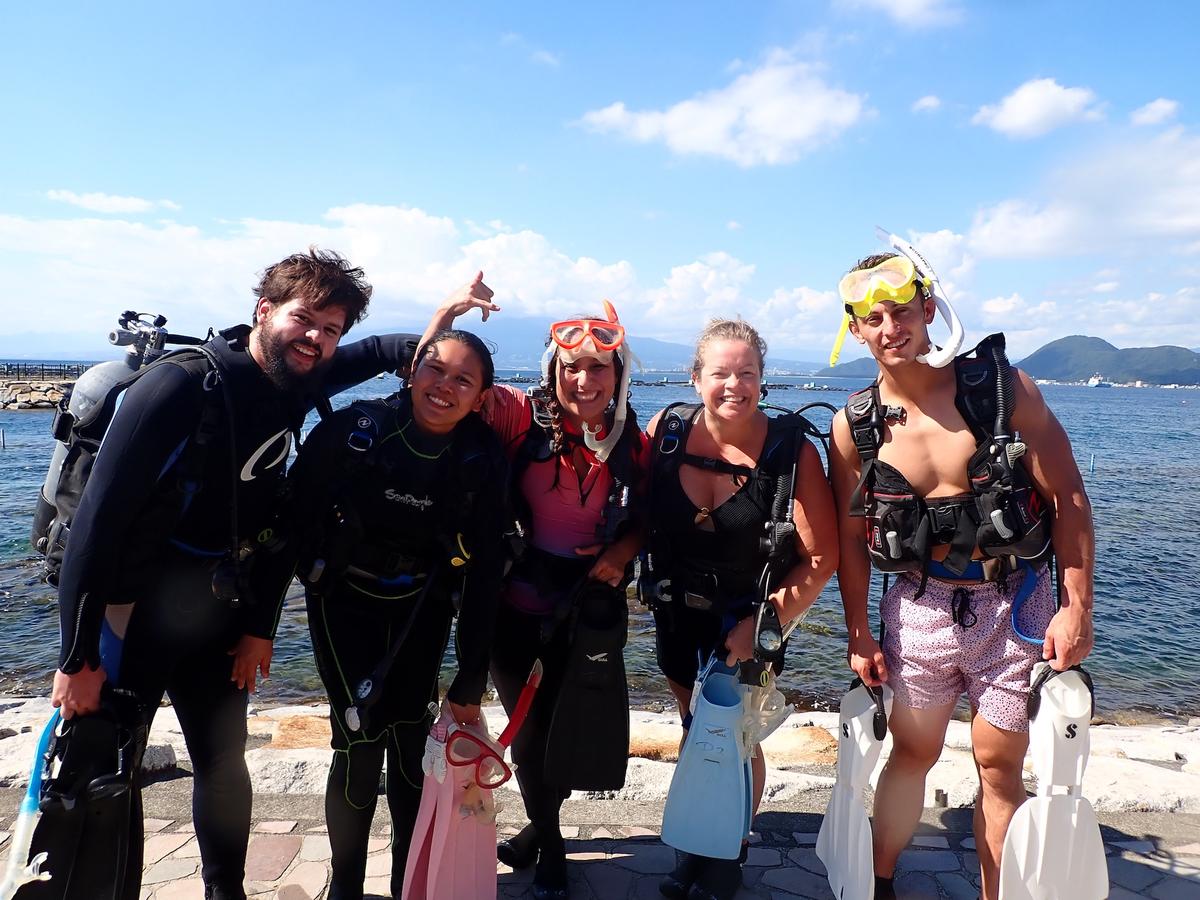 Group photo of DIVE DREAM guests celebrating their scuba diving C-card certification in Izu, Japan