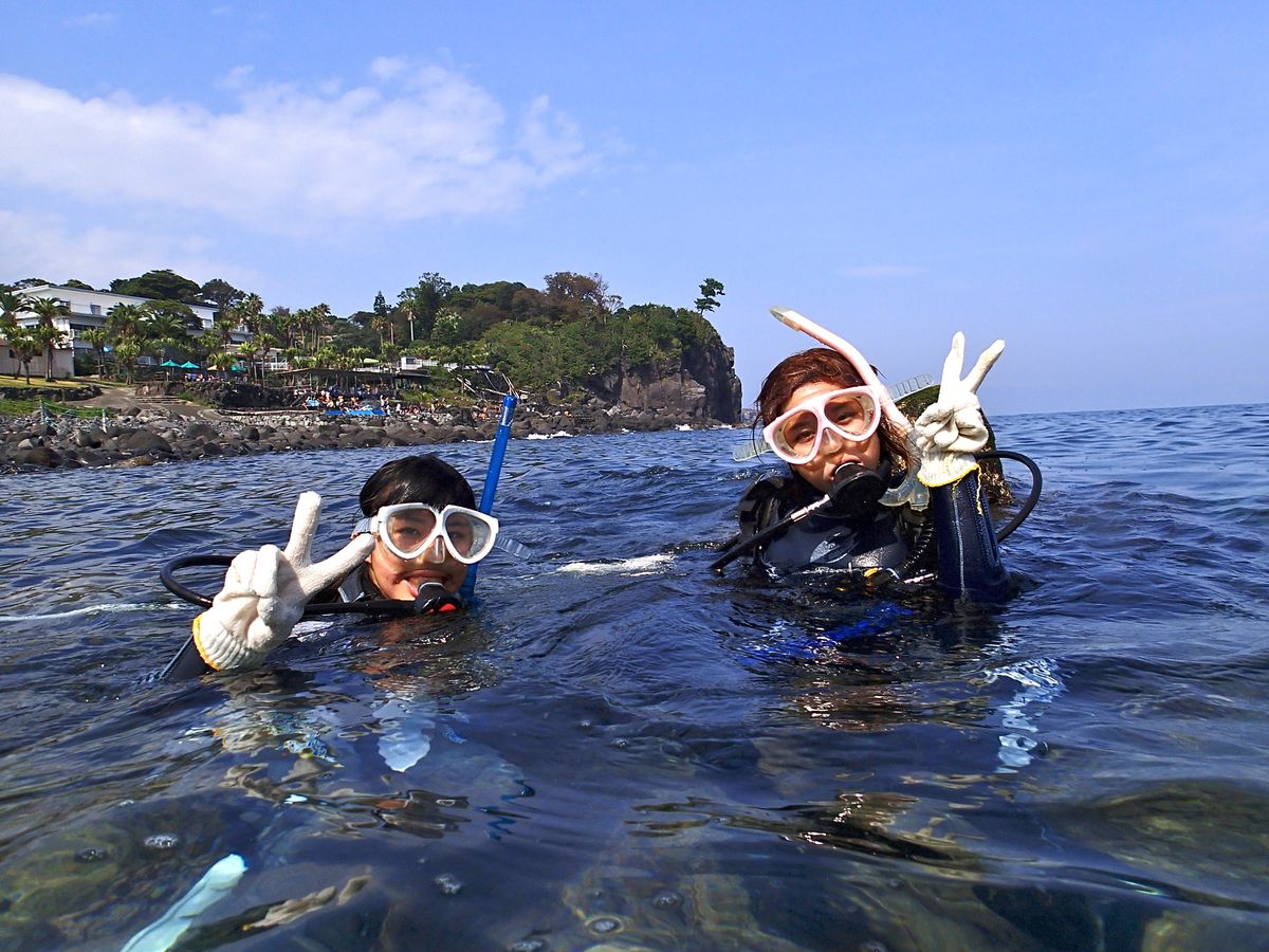 海面で2人そろってピースサインをする体験ダイビング参加者